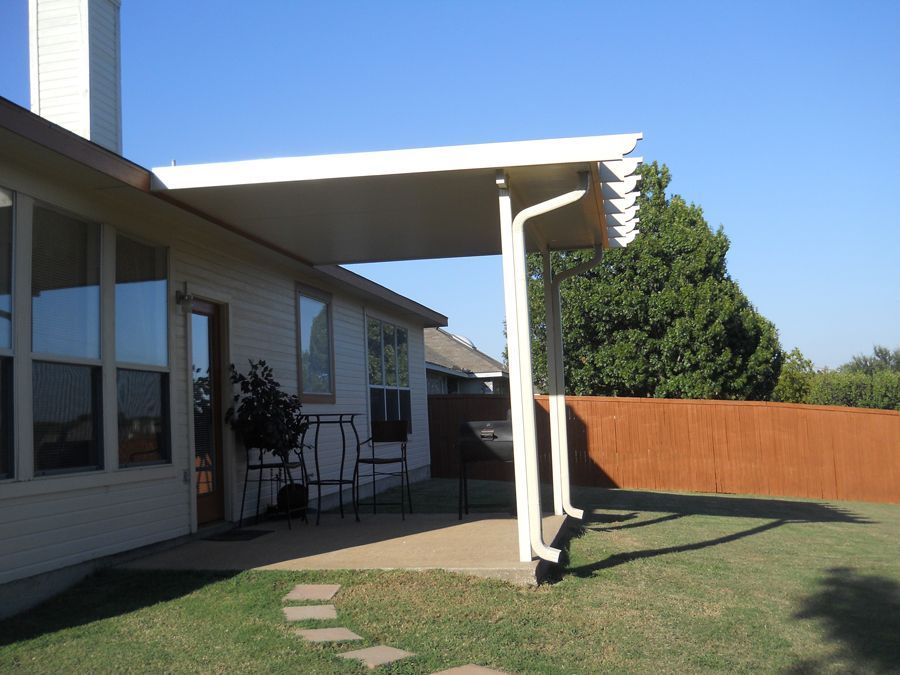 The backyard of a house with a covered patio