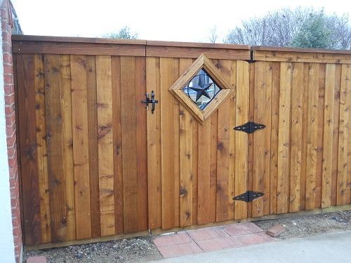 A wooden fence with a window in the middle of it