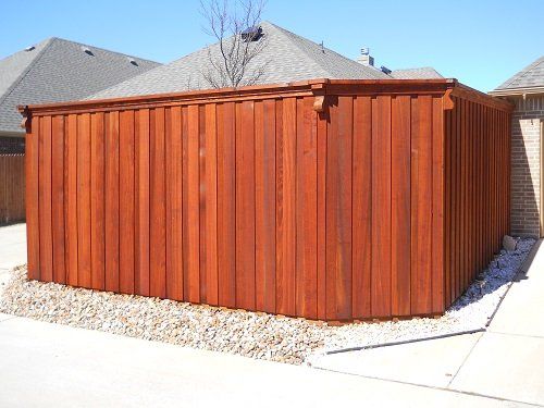 A wooden fence is sitting in front of a house.