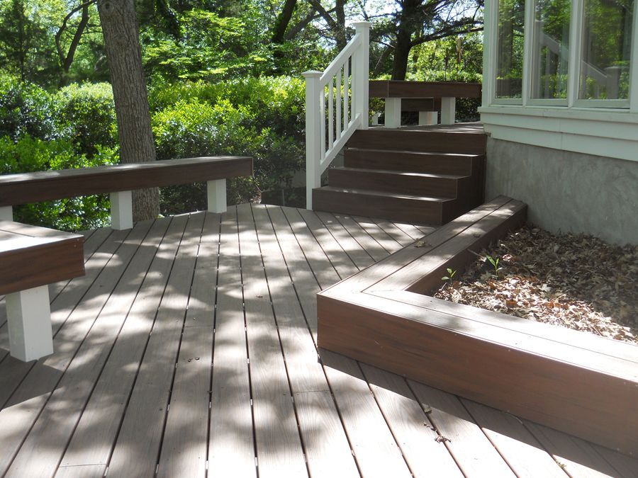 A wooden deck with stairs and a white railing