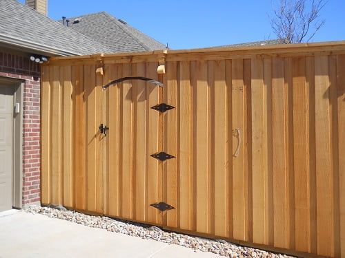 A wooden fence with a brick building in the background