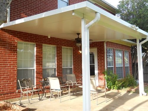 A brick house with a white patio cover over it