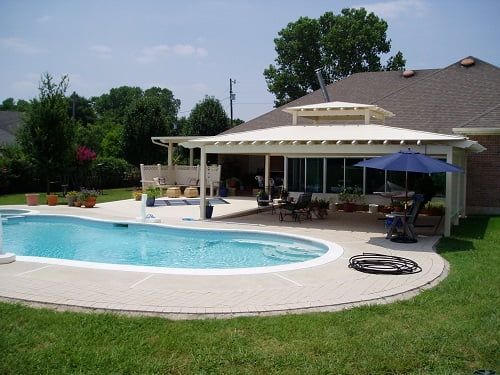 A house with a large swimming pool in front of it