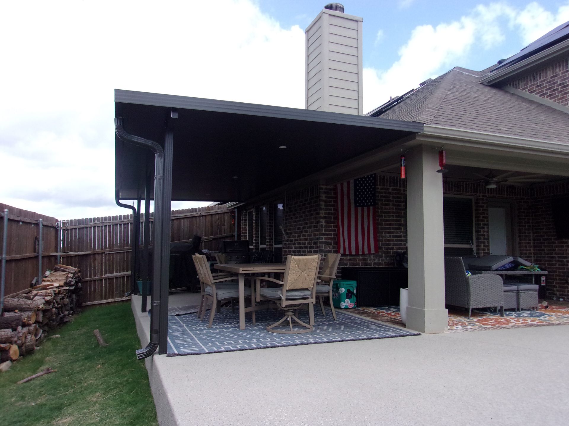 A white patio cover with a grill underneath it