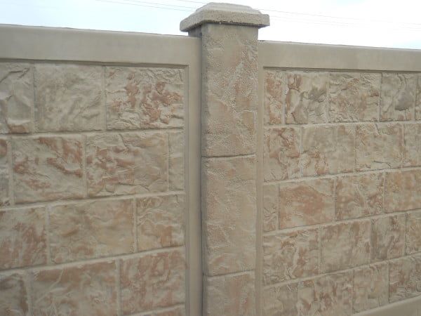 A close up of a brick wall with a post in the middle.