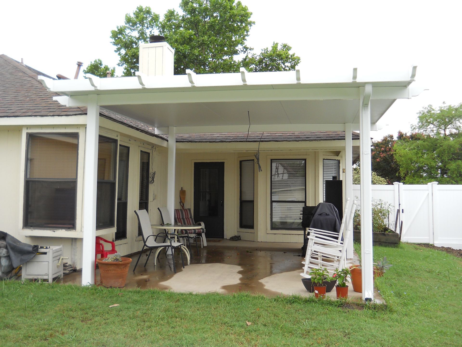 A white covered porch with a picnic table and a fire hydrant.