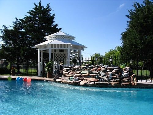 A swimming pool with a gazebo in the background