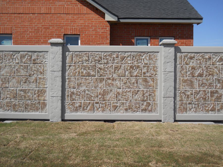 A brick house with a stone fence in front of it