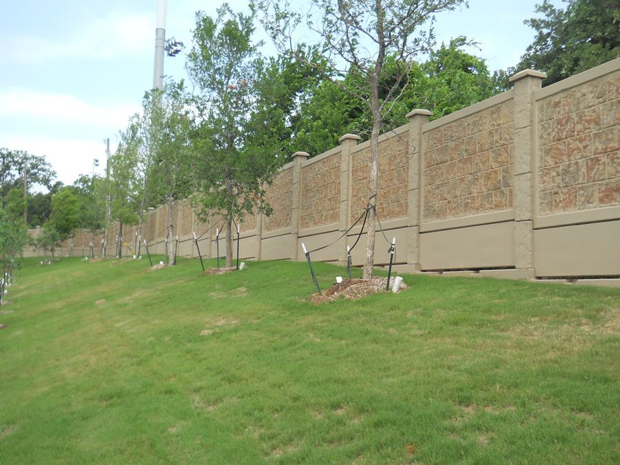 A fence with trees in front of it in a park