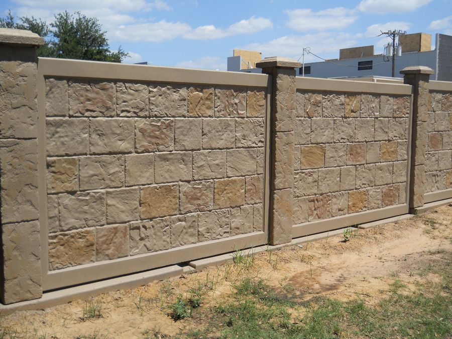 A stone fence surrounds a lush green field