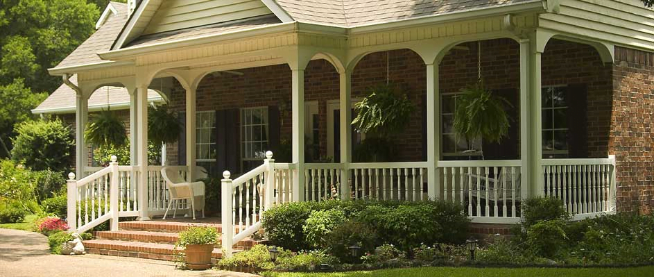 A brick house with a screened in porch and stairs