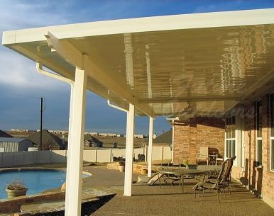 A covered patio with a pool in the background
