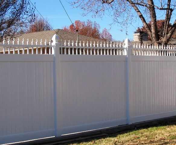 A white fence with a house in the background