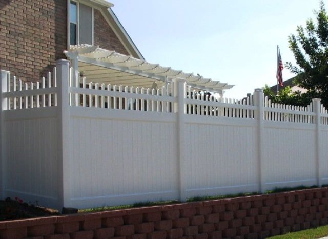 A white fence with a pergola on top of it