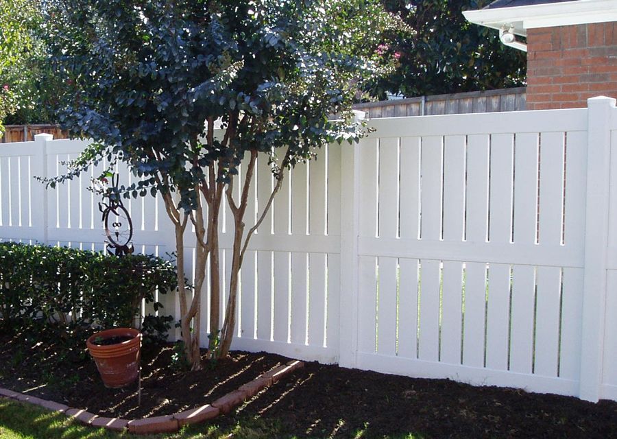 A white fence with a tree in the background