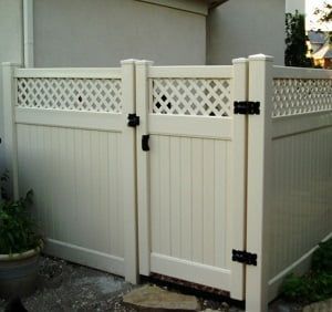 A white fence with a gate in front of a house.