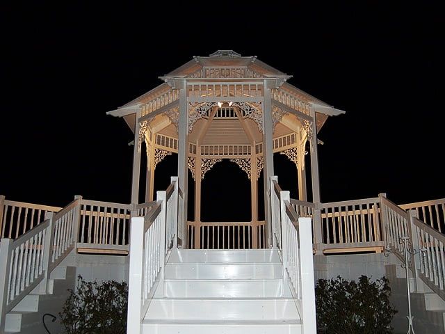 A gazebo with stairs leading up to it at night