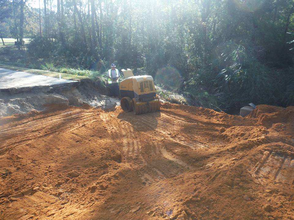 a yellow bulldozer is working on a dirt road