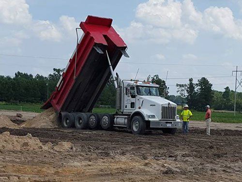 a dump truck is being loaded with dirt on a construction site