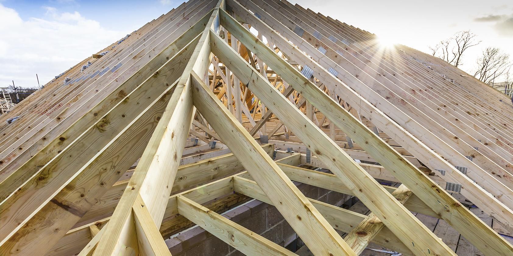 The roof of a house is being built with wooden beams.