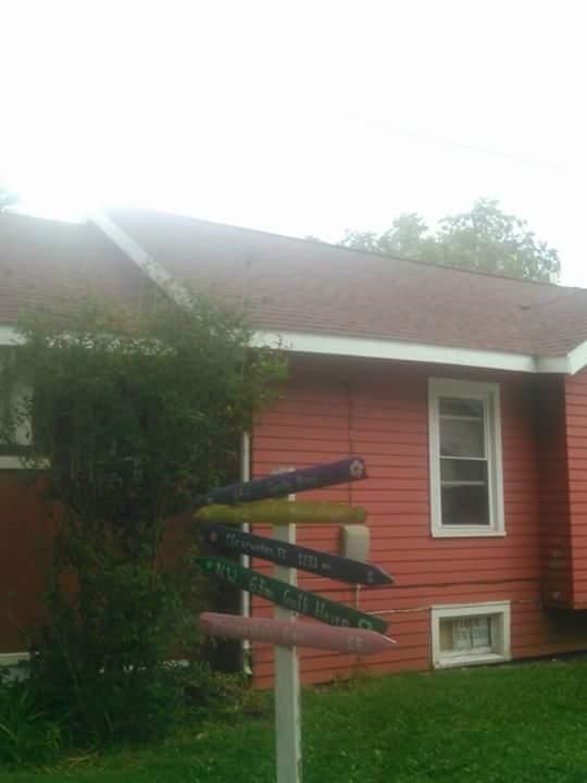A red house with a bunch of signs in front of it