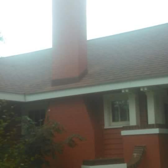 A red house with a chimney on the roof