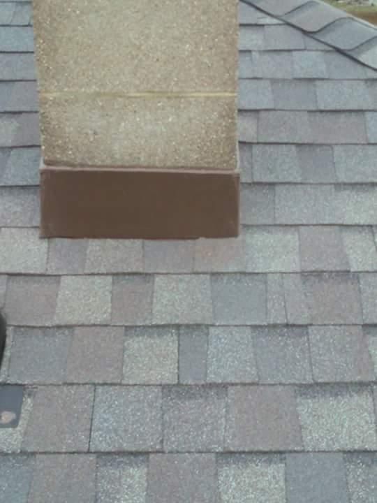 A chimney on top of a roof with shingles