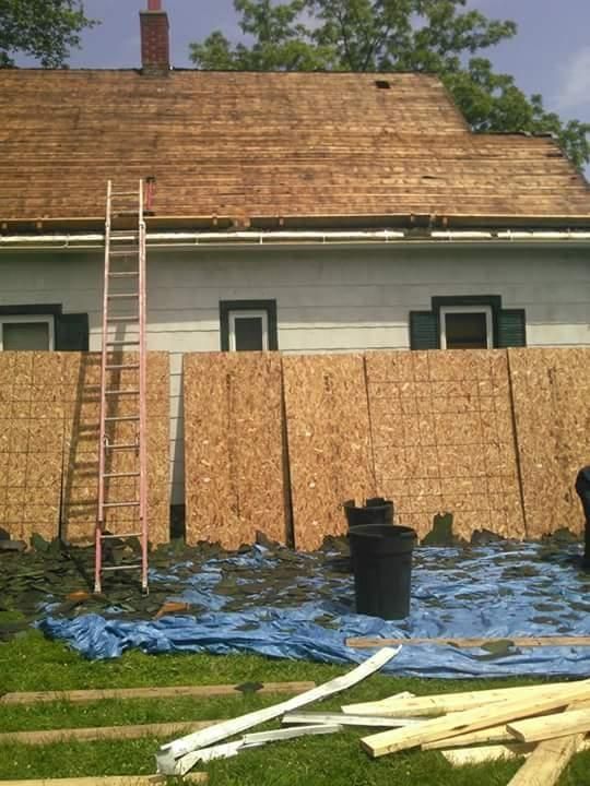 A ladder is sitting in front of a house that is being boarded up
