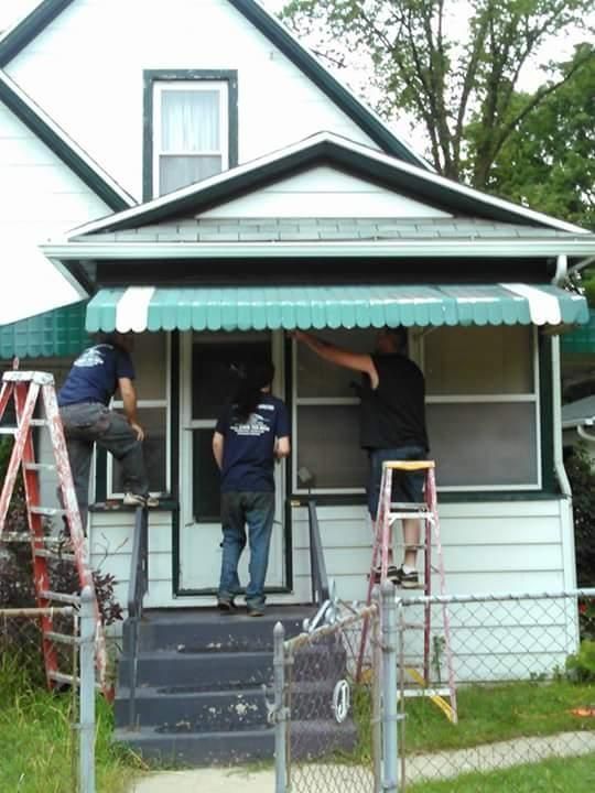 A group of men are working on the front of a house