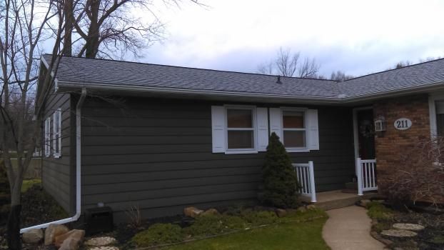 A house with a gray siding and white shutters