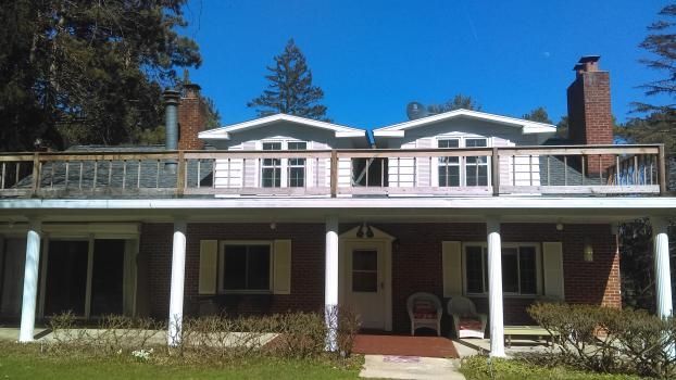 A large house with a large porch and a balcony