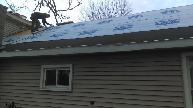 A man is working on the roof of a house.