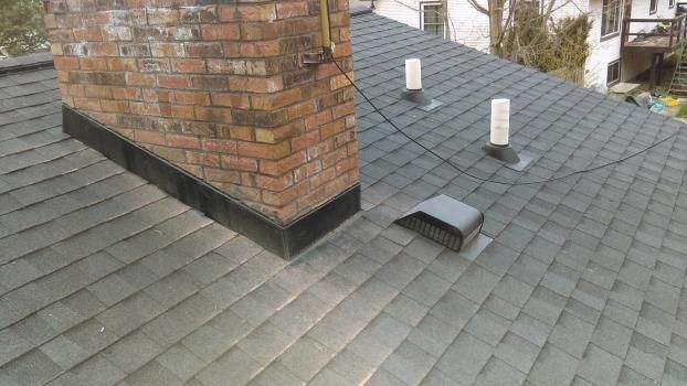 There is a chimney on the roof of a house.