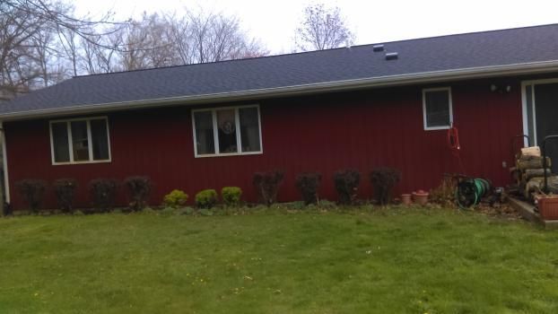 A red house with a black roof and a lot of windows