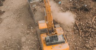 An aerial view of a yellow excavator working on a construction site.