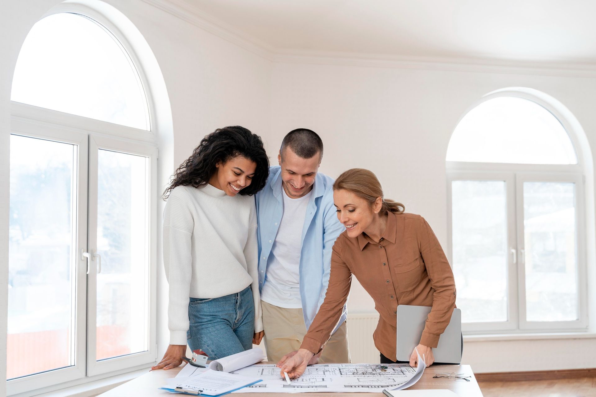A group of people are looking at a blueprint of a house.