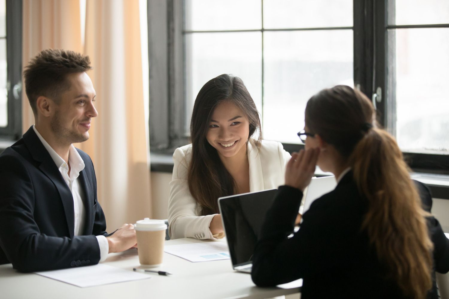 A group of people are sitting at a table having a meeting.