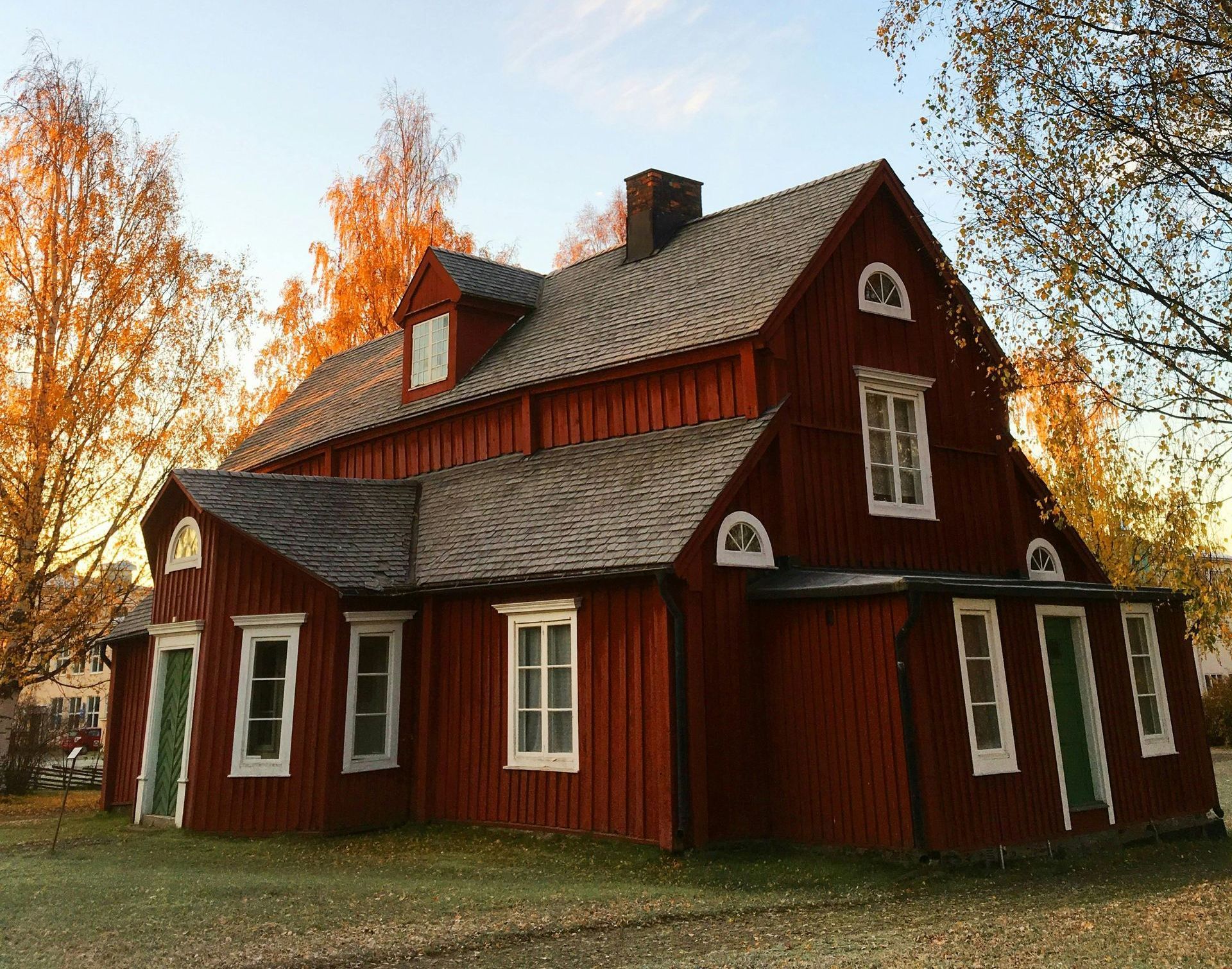 A red house with a gray roof and white windows