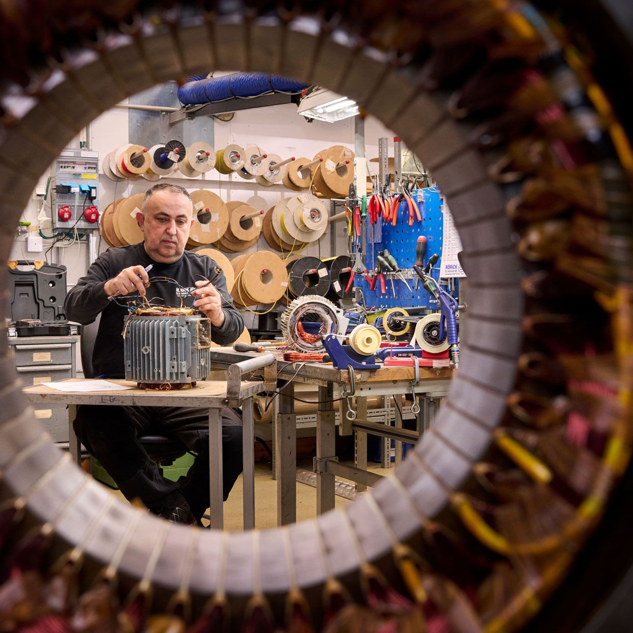 En man arbetar på en maskin med en gul triangel på