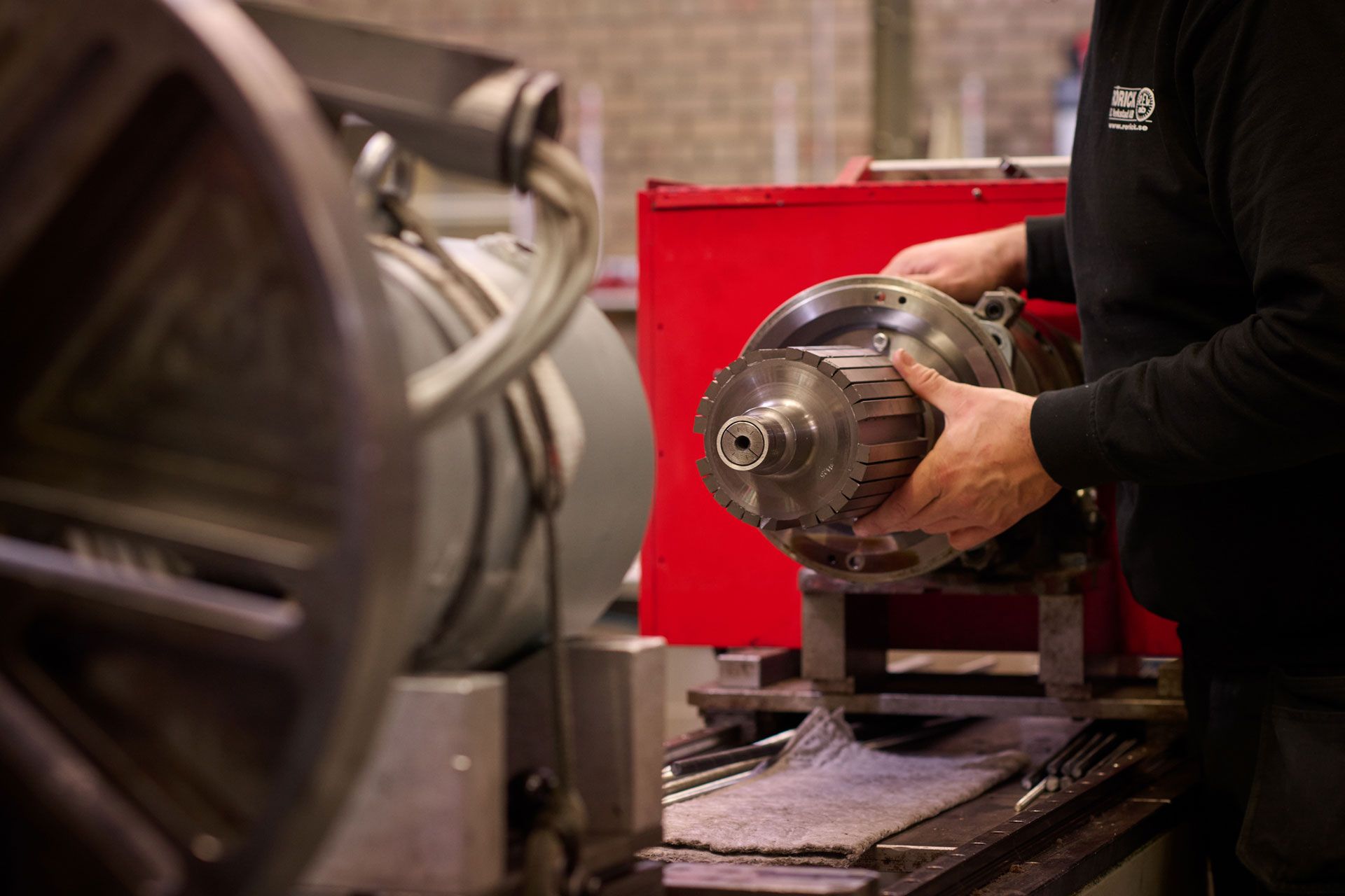 En man arbetar på en elmotor i en verkstad.