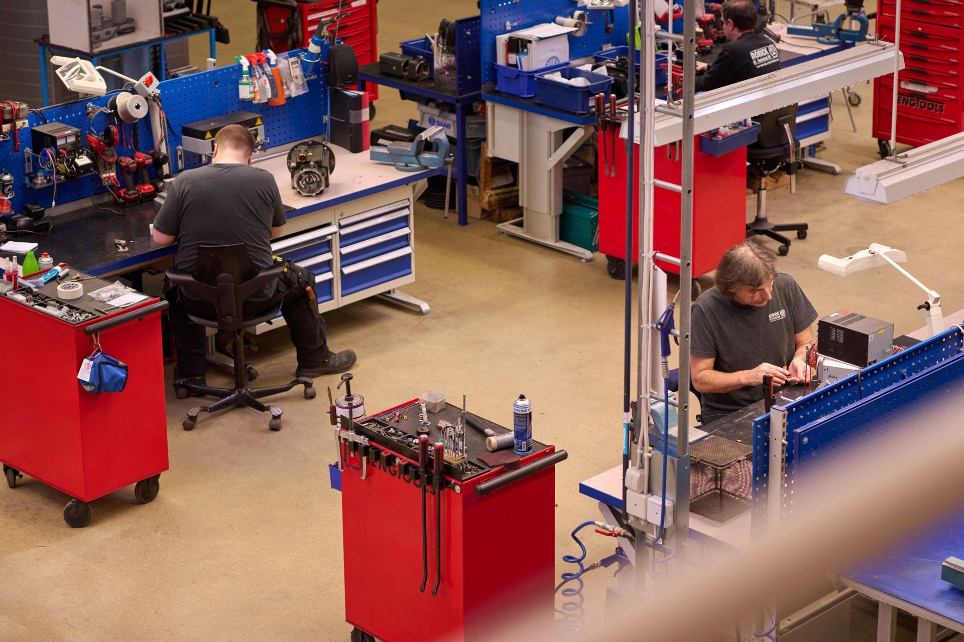 En man lindar om en stor elmotor i en fabrik.