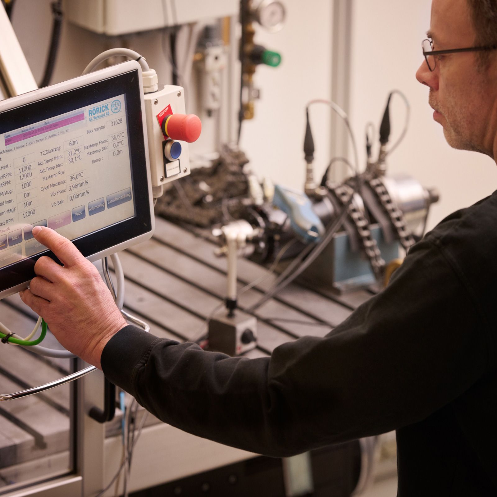 En man i en lila skjorta arbetar i en fabrik