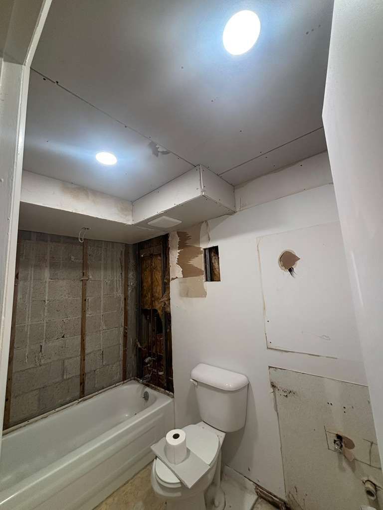 A bathroom that is under construction with an exposed shower wall