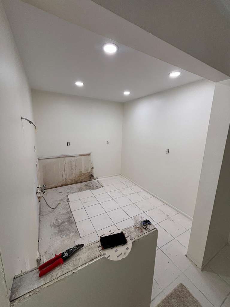 A room with a partially tiled floor and wall connections