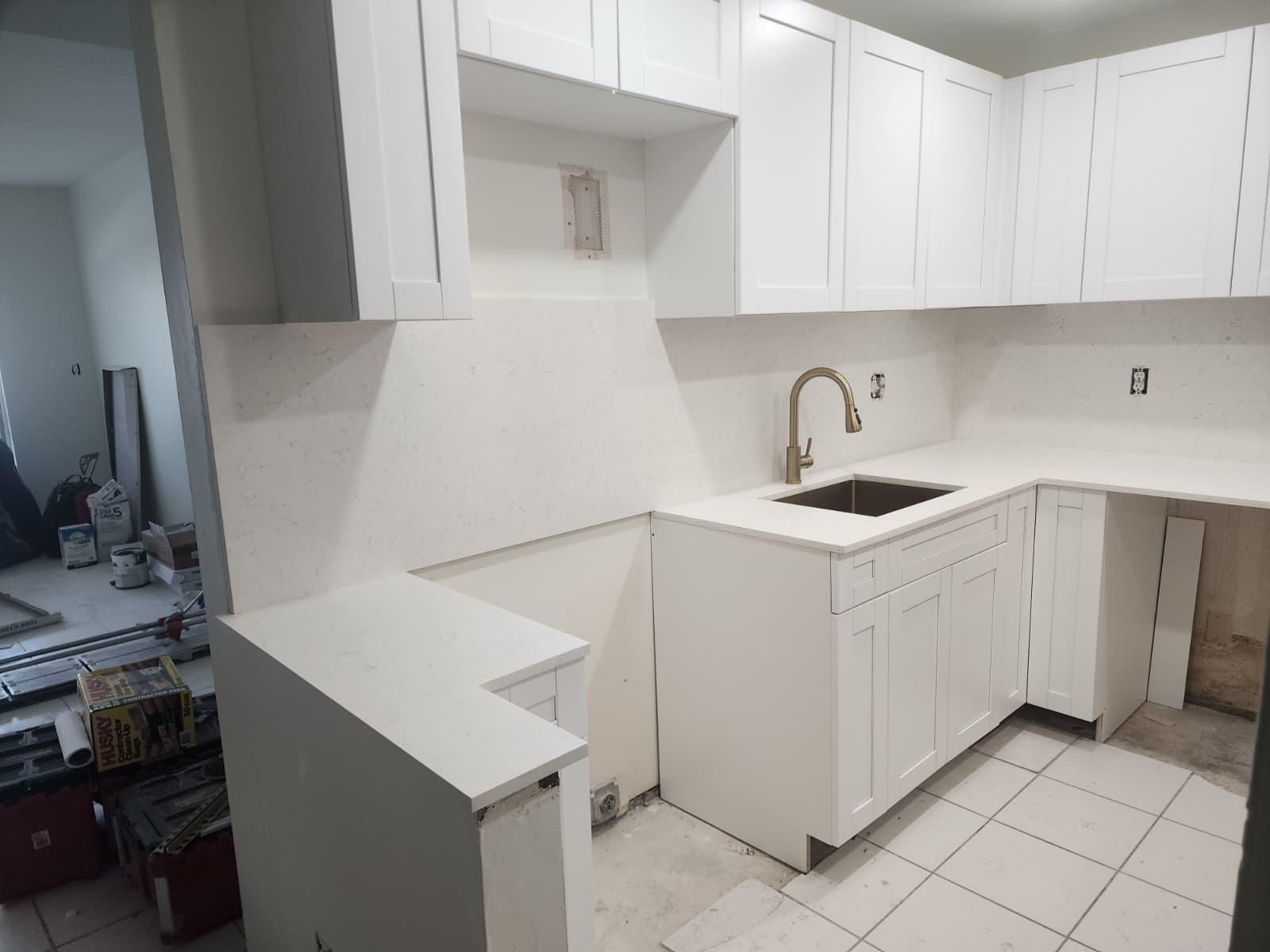 A kitchen space with cabinets and a sink