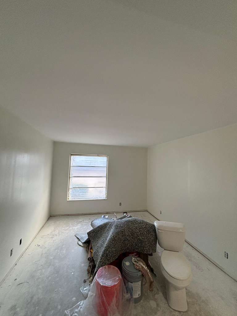 A room with a toilet and construction equipment in the middle of the floor