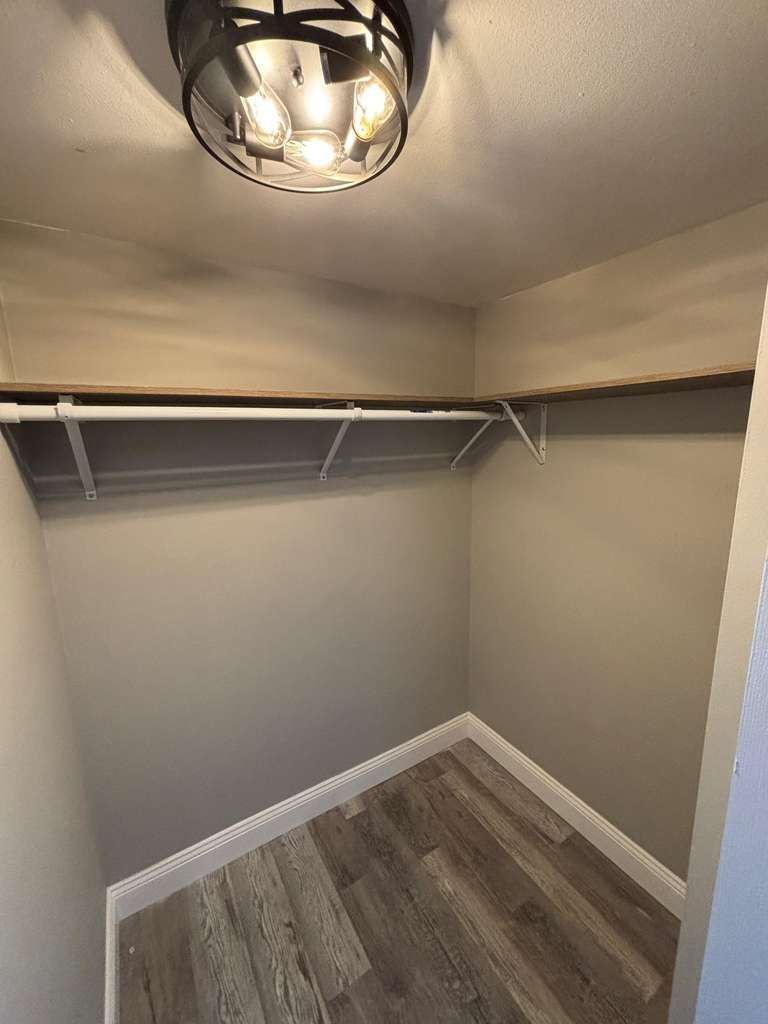 A closet with a light fixture and a shelf