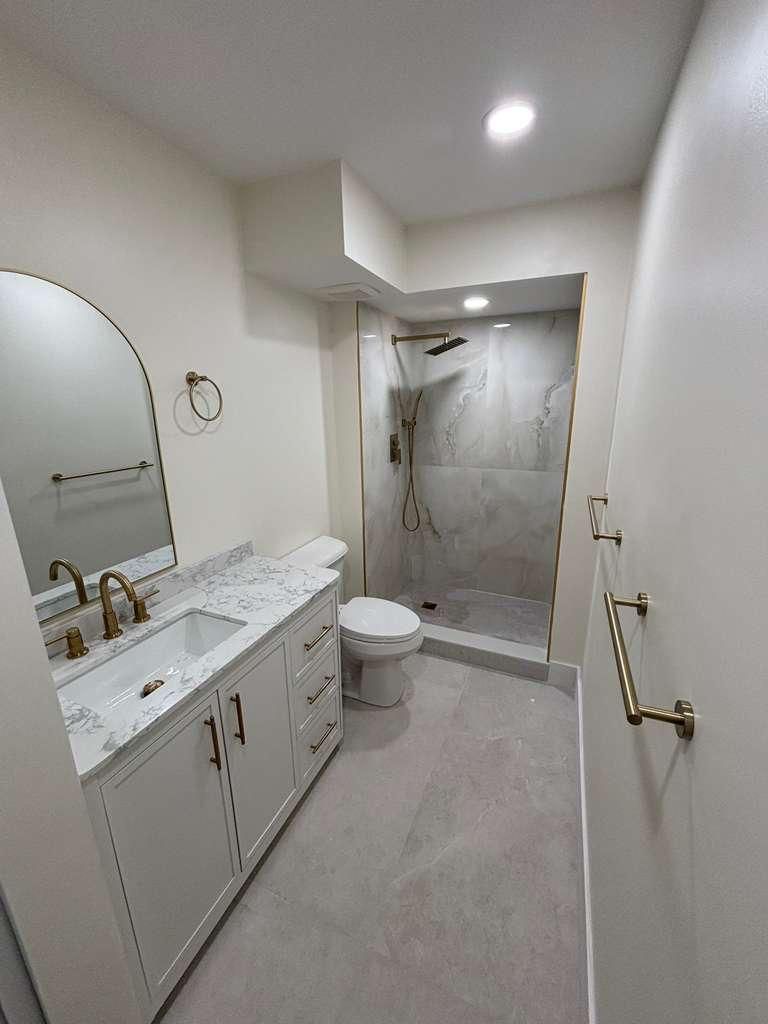 A renovated bathroom with gold hardware