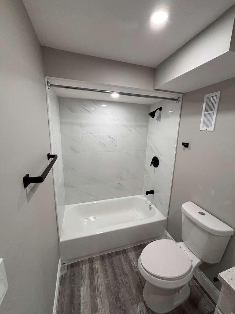 I renovated shower with a black towel rack