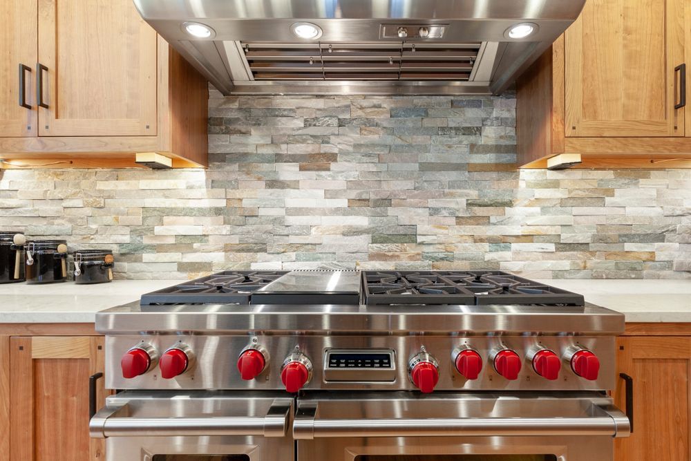 Modern kitchen with island and four clear bar stools; white cabinetry, wooden accents.